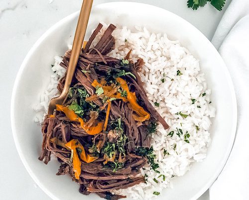 Cuban ropa vieja with white rice in a bowl.