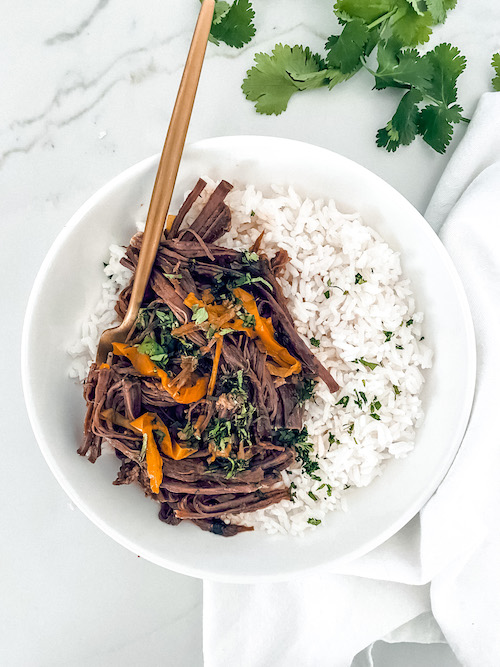 Cuban ropa vieja with white rice in a bowl.