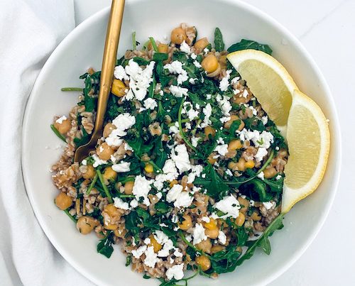 Farro and chickpea with lemon wedges in a bowl.