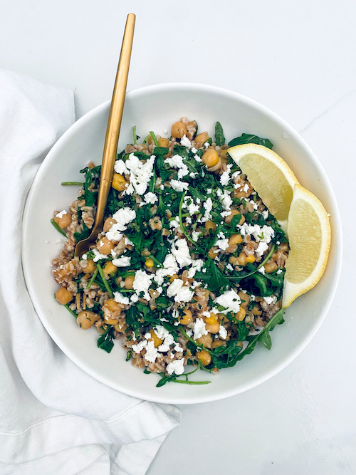 Farro and chickpea with lemon wedges in a bowl.