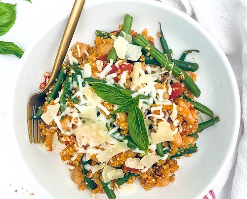 Italian quinoa casserole with green beans in a white bowl.