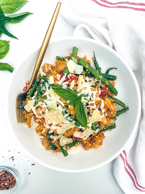 Italian quinoa casserole with green beans in a white bowl.
