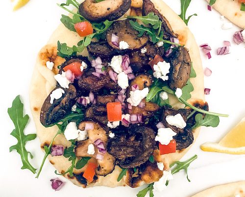 Thick pita layered with mushroom gyro and arugula.
