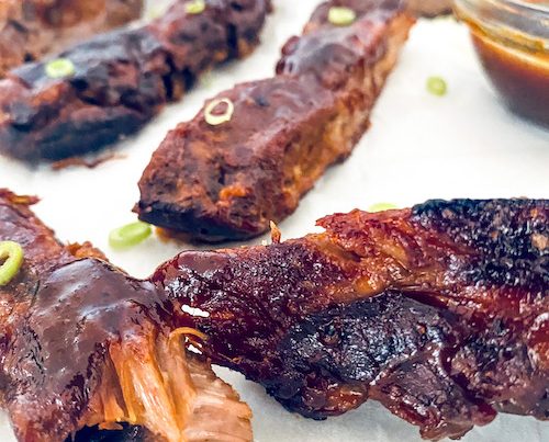Pineapple BBQ ribs on a white surface.