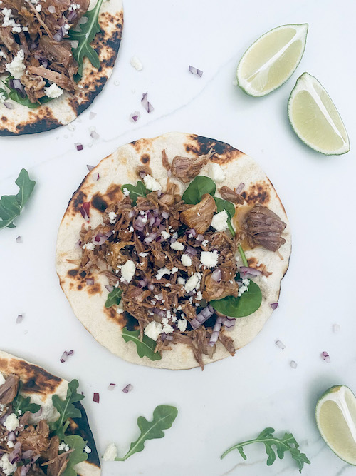A pork al pastor taco on a white counter.