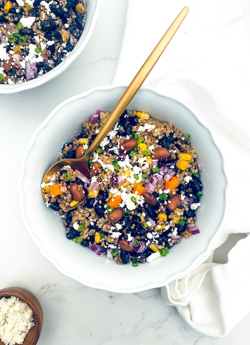 A white bowl of quinoa burrito bowl.