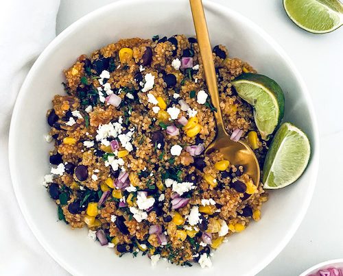 Southwest quinoa black bean bowl with lime wedges.