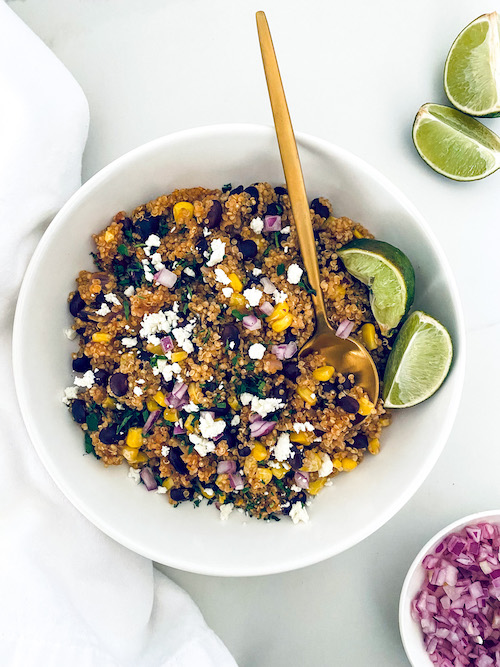 Southwest quinoa black bean bowl with lime wedges.