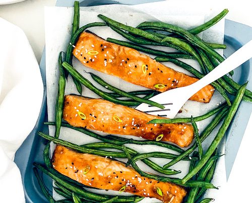 Teriyaki salmon with green beans on a baking dish.