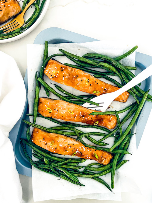 Teriyaki salmon with green beans on a baking dish.