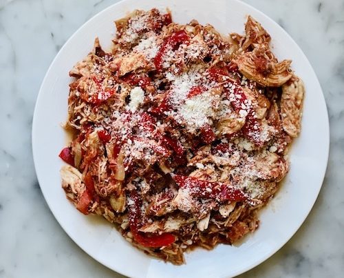 A white plate filled with chicken cacciatore.