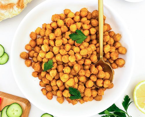 A white bowl of chickpea shawarma topped with parsley.