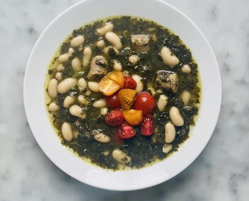 White bean and pesto soup in a white bowl.