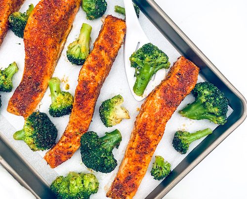 Blackened Salmon +Broccoli on a parchment lined baking sheet.