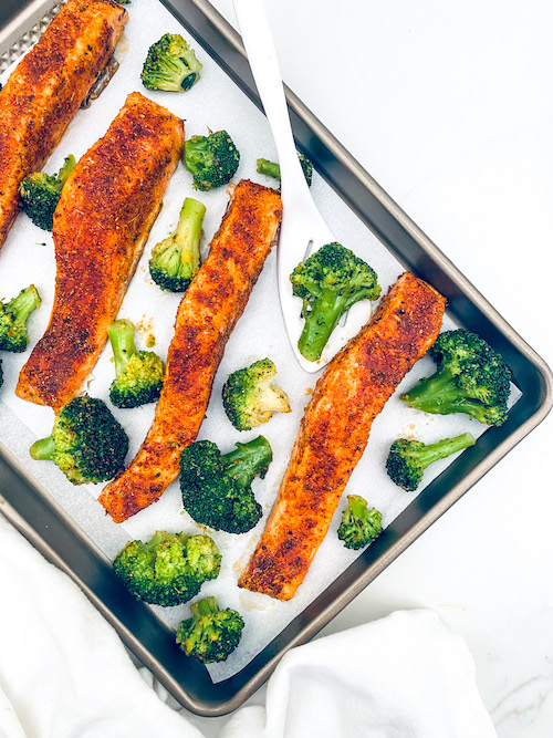 Blackened Salmon +Broccoli on a parchment lined baking sheet.