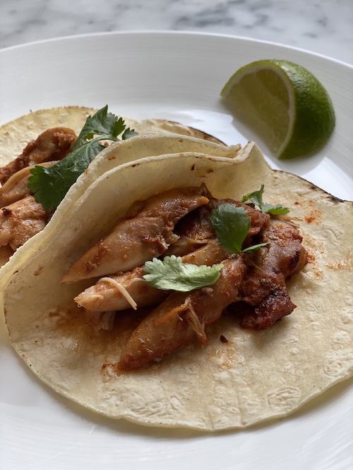 Brown sugar chipotle chicken slices in corn tortillas.