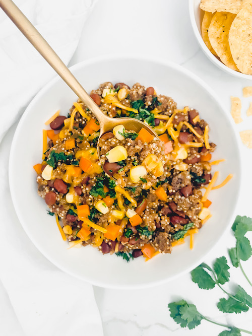 Mexican Casserole in a large white bowl with a golden spoon.