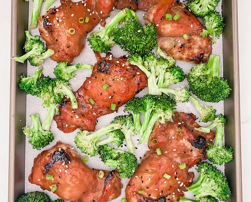 Sheet Pan Honey Garlic Chicken + Broccoli on a parchment lined baking sheet.