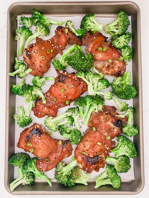 Sheet Pan Honey Garlic Chicken + Broccoli on a parchment lined baking sheet.