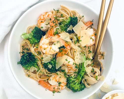 Shrimp Scampi with Linguine + Broccoli in a white pasta bowl with a fork.