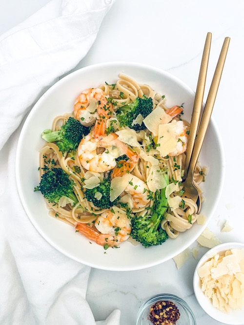 Shrimp Scampi with Linguine + Broccoli in a white pasta bowl with a fork.