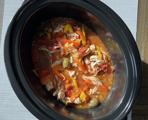 A crockpot insert filled with lemon braised chicken.