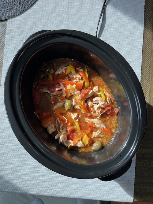 A crockpot insert filled with lemon braised chicken.