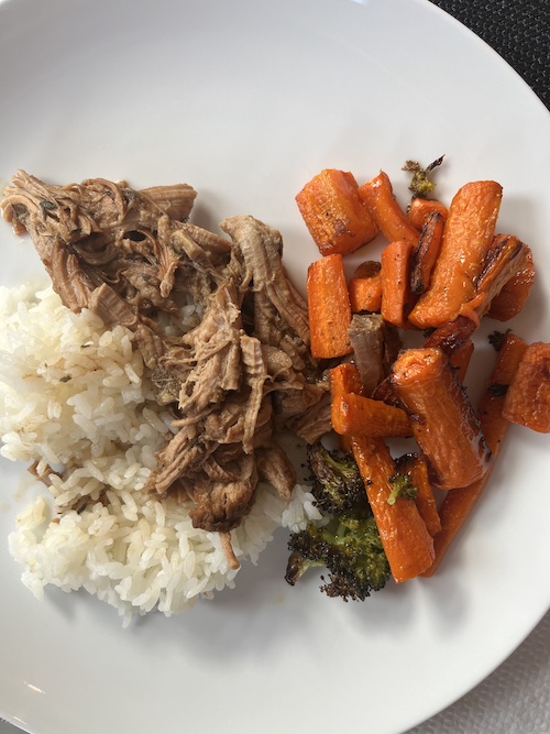 Mongolian beef, white rice, and roasted carrots on a white plate.