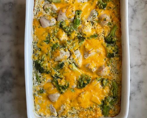 Orzo broccoli chicken bake in a white casserole dish.