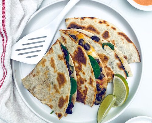 Black bean and cheese quesadilla sections on a white dinner plate.