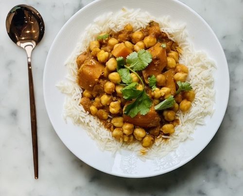 Vegetarian chickpea tikka masala over white rice on a plate.