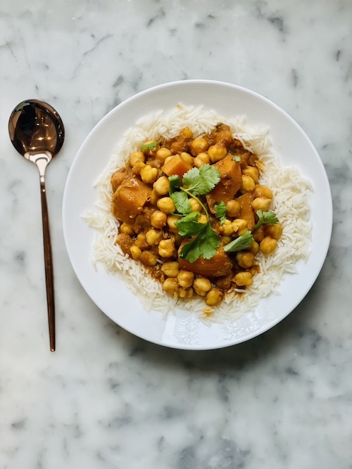 Vegetarian chickpea tikka masala over white rice on a plate.