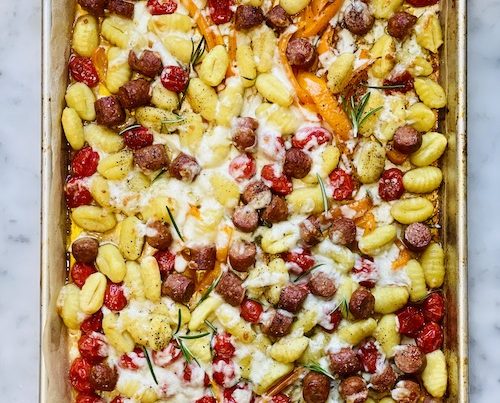 Gnocchi and veggies in a parchment lined sheet pan.