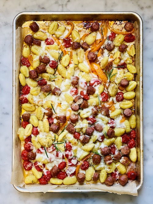Gnocchi and veggies in a parchment lined sheet pan.