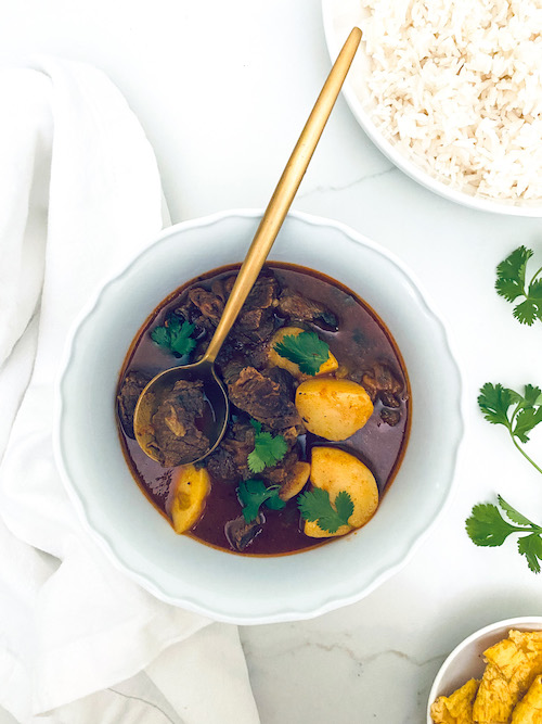 Carne guisada with potatoes in a white bowl.