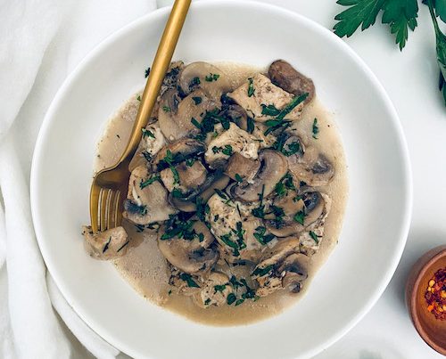 Chicken and marsala mushrooms in a deep white bowl.