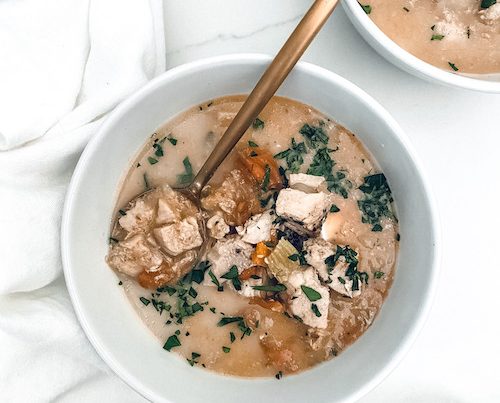 A white bowl filled with chicken vegetable soup.