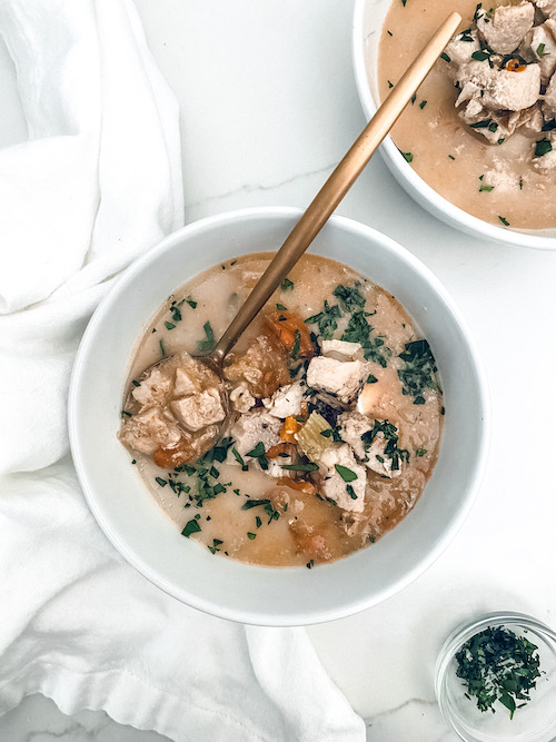 A white bowl filled with chicken vegetable soup.