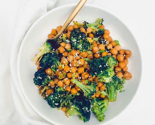 Honey Sriracha Chickpeas + Broccoli in a white bowl with a gold fork.