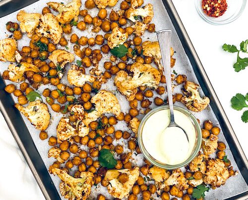 Sheet Pan Dorito Cauliflower + Chickpeas on a parchment lined pan.