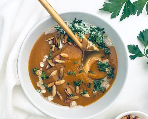 A white bowl filled with vegetarian autumn squash soup.
