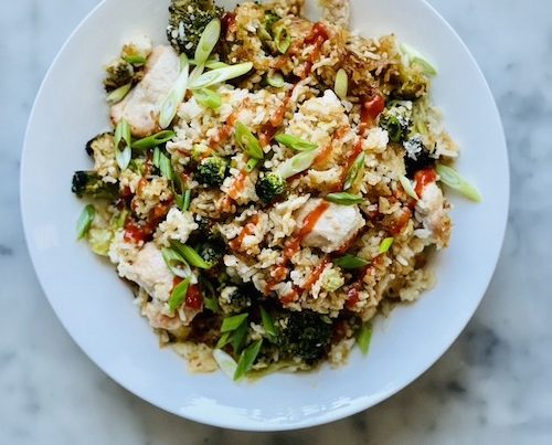Chicken and broccoli fried rice on a white dinner plate.