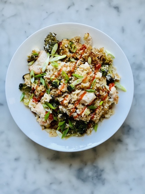 Chicken and broccoli fried rice on a white dinner plate.