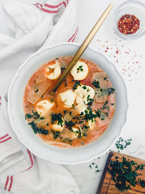 Tortellini soup with chives and cheese.