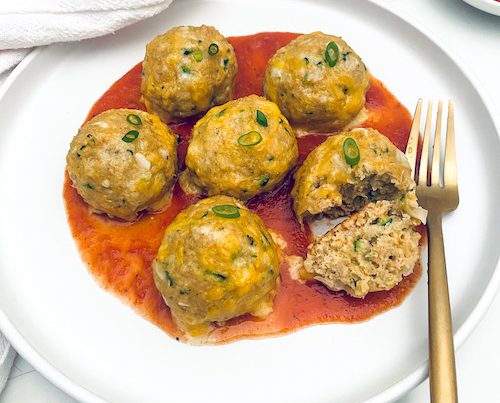 Turkey taco meatballs and red sauce on a white plate.