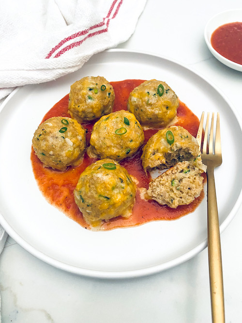 Turkey taco meatballs and red sauce on a white plate.