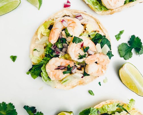 Cilantro lime shrimp and diced onions on corn tortillas.