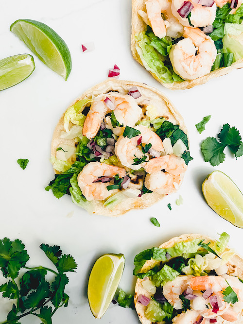 Cilantro lime shrimp and diced onions on corn tortillas.