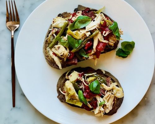 Antipasto toppings with chicken on slices of toast.