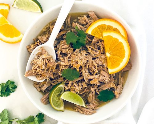 Shredded citrus mojo pork in a white bowl.